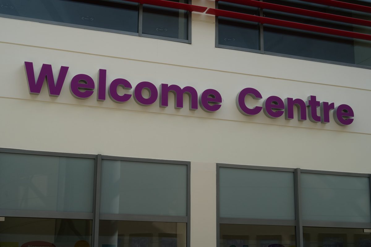 The Welcome Centre sign mounted on the exterior wall of the university building.