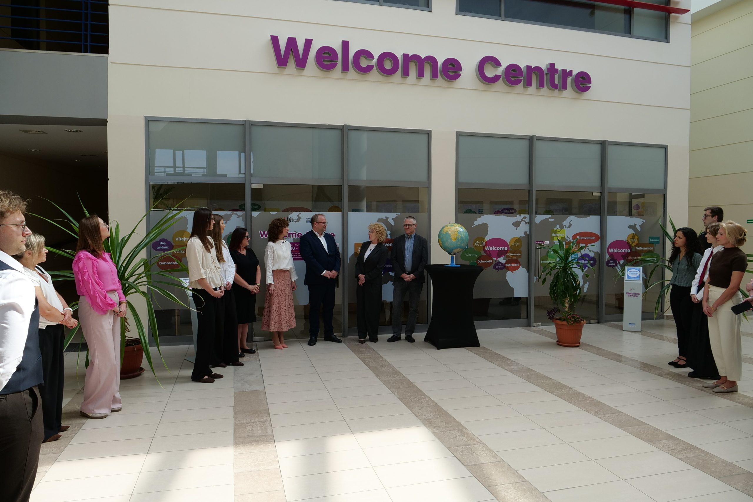 University representatives and guests gather around a globe during the official opening of Welcome Centre UJK in Kielce.